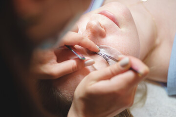 Aesthetic medicine: eyelash extension procedure for young woman