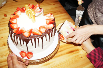 A woman cuts a birthday cake and puts it in saucers