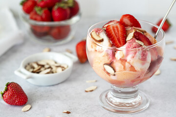 Ice cream with strawberry and almonds in a vase