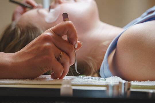 Aesthetic medicine: eyelash extension procedure for young woman