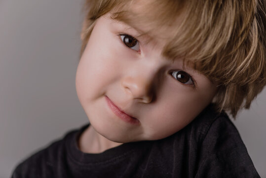 Little cute caucasian boy kid 3years old wearing black t-shirt against white wall showing while smiling confident and happy.