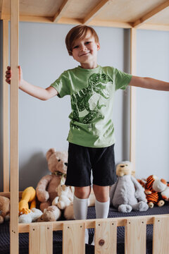 5 years boy playing in his room, wearing green t-shirt with dinosaurus print