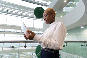 African American analyst browsing tablet near railing