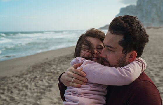 Father and daughter on the ocean shore
