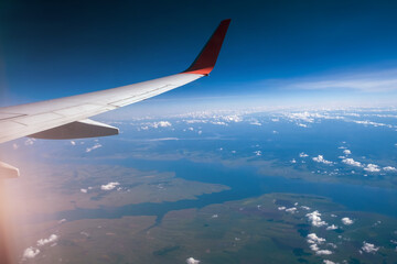 Obraz premium Classic image through aircraft window onto wing. Flight view over Russia