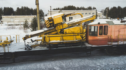 Construction train with yellow machine with locomotive
