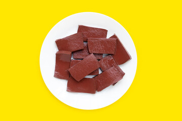 Pork blood pudding in white plate on yellow background.