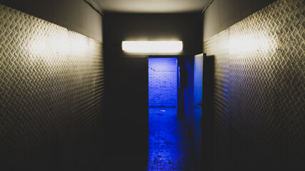 Blue light behind an open door in a mysterious corridor. secret entry