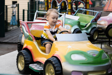 A child rides a car in the amusement park.