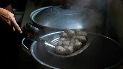 lift meatballs from boiling water in a big pot