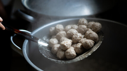 lift meatballs from boiling water in a big pot