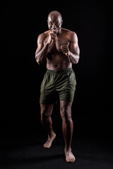 Fototapeta na wymiar Muscular adult male smiling standing in defensive boxing pose