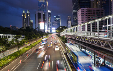 Fototapeta na wymiar Traffic captured with blurred motion is rushing on the Jakarta main business and financial district at dusk in the modern Indonesia capital city