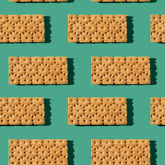 Photo in the form of a seamless pattern. Orange color loafs for healthy food with shadows on a colored green background.