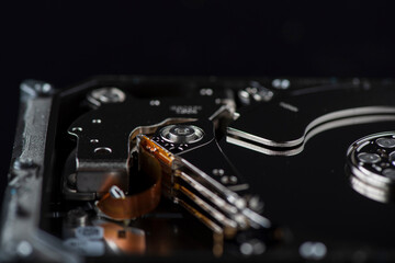 Fragment of a disassembled hard drive, against a dark background.