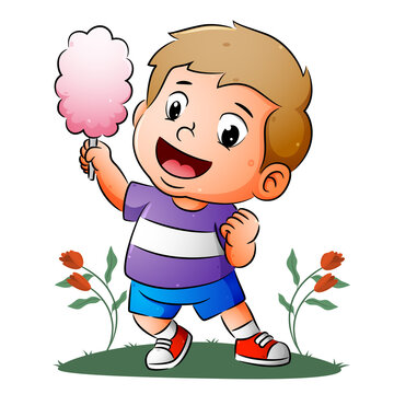 The happy boy is holding the big colored cotton candy