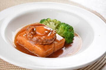 braised whole big abalone with bean curd tofu and broccoli in chef premium oyster sauce in white background asian halal seafood menu