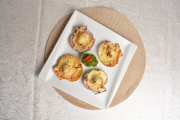 baked cheese cream scallop in shell foie gras canapés in white background asian halal seafood menu