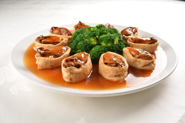 braised fresh oyster in bean curd tofu skin and broccoli with chef special oyster sauce in white background asian halal seafood menu