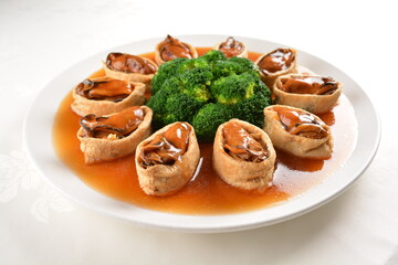 Obraz na płótnie Canvas braised fresh oyster in bean curd tofu skin and broccoli with chef special oyster sauce in white background asian halal seafood menu