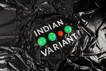 words indian variant laid with silver metal letters on crumpled black plastic bag background with...