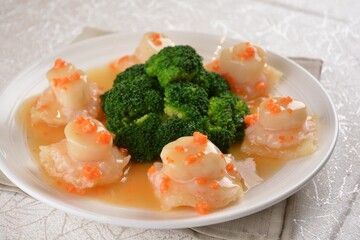 braised fresh scallop with fish maw, roe and broccoli in thick sauce in white background asian halal seafood menu