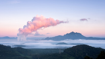 Beautiful sea of fog in the mountains, green forest and steam from the coal-fired power plant in the morning sunrise . Mae moh, Lampang, Thailand