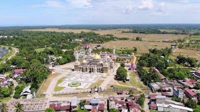 Aerial video of the Baitul Ghafur Grand Mosque in southwest Aceh shows the courtyard and main road from the front with the drone moving to the left