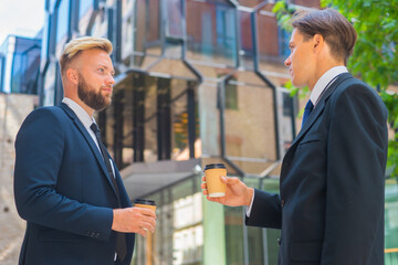 Confident businessman and his colleague in front of modern office building. Financial investors are talking outdoor. Banking and business.