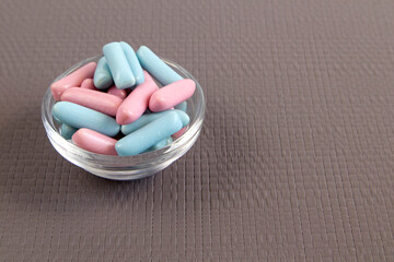 Jar full of blue and pink candies against soft grey background