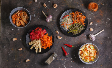 Fermented foods. Assorted Korean pickled salads and home-made fermented vegetables in plates on a dark background. Copy space, flat lay, top view