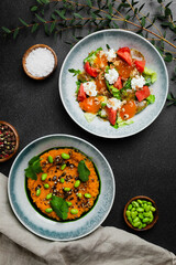 salad with fresh vegetables and stracciatella and salad with fresh green pea or green beans salad top view in concrete table with copy space