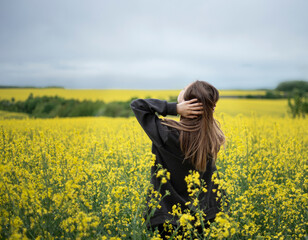 Young girl on yellow rapeseed field