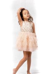 Naklejka premium Portrait of happy pretty curly little girl standing and posing over white background