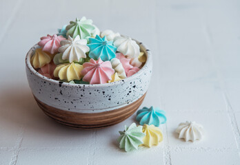 Small colorful meringues in the  ceramic bowl