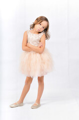 Portrait of happy pretty curly little girl standing and posing over white background