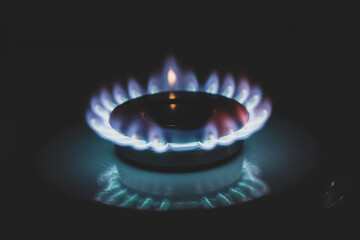 Gas burner on stove. Selective focus. Blue propane gas burns on the kitchen gas stove. consumer...