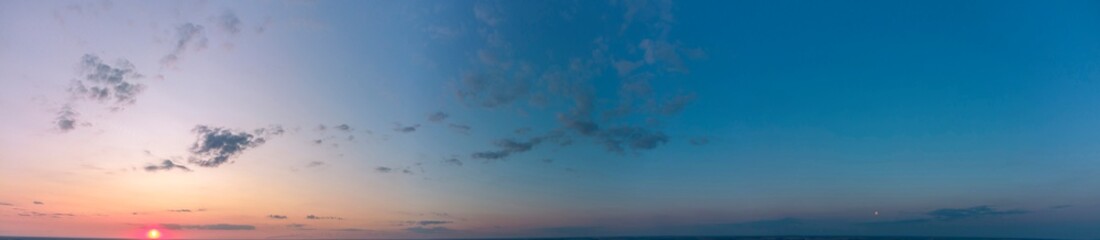 Fototapeta na wymiar Panorama of the sunset. Orange and blue sky.