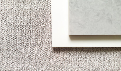 close up white and grey artificial stone samples placed on textile beige yarn fabric background...