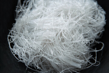Asian food close-up heap of raw glass noodle or wun sen and fensi in a black bowl background © 9gifts