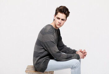 young handsome teenage hipster guy posing against grey background isolated, lifestyle people concept