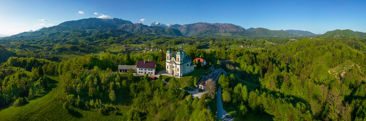 Fototapeta na wymiar Pilgrimage church St. Anne in Tunjice and in background Kamnik - Savinja Alps, Slovenia