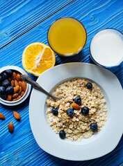 Healthy eating, food and diet concept - tasty oatmeal with berries and glass of orange juice.