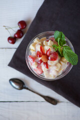 Fresh fruit salad with Greek yogurt in a glass glass. Vegetarian dessert.