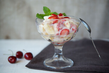 Fresh fruit salad with Greek yogurt in a glass glass. Vegetarian dessert.