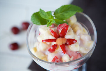 Fresh fruit salad with Greek yogurt in a glass glass. Vegetarian dessert.