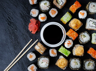 Set of sushi and maki on stone table.