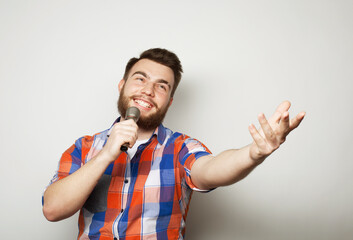 Handsome man with beard singing with microphone