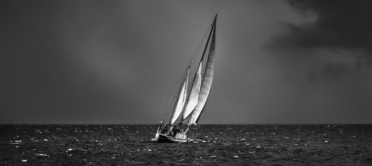 Old expensive vintage two-masted sailboat (yawl) close-up, sailing in an open sea during the storm....