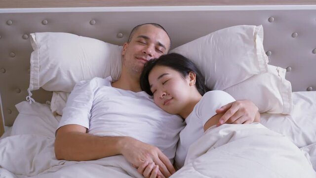 Young couple sleeping together on a bed